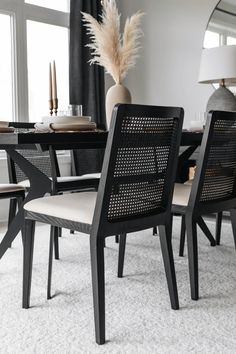 a dining room table with chairs and a vase on it