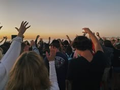 a group of people raising their hands in the air