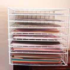 a stack of papers sitting on top of a white shelf