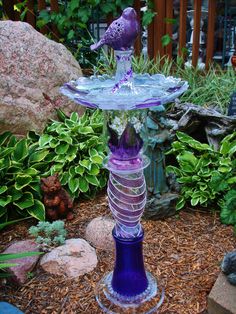 a purple glass bird bath sitting on top of a stand