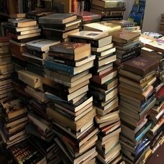 a large stack of books sitting on top of a table