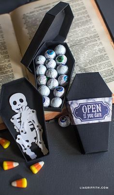 an open book with candy in it next to some halloween candies on the table