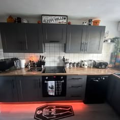 a kitchen with grey cabinets and black appliances