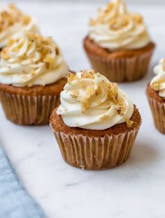 several cupcakes with white frosting and sprinkles