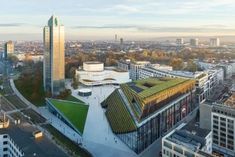 an aerial view of a green roof on top of a building in the middle of a city