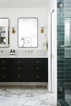 a bathroom with two sinks and mirrors on the wall next to a walk in shower