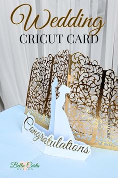 Left side view of an elegant gold and white pop-up card featuring a detailed silhouette of a bride and groom. The intricate, ornate background designs are prominently displayed, enhancing the card's luxurious look. The front reads 'Congratulations' in gold script. Ornate Gate, Diy Cricut Projects, Wedding Card Maker, Congratulations Message, Crafts By Season, Htv Projects, Svg Templates