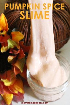 pumpkin spice slime in a glass jar next to fall leaves and a ball of yarn