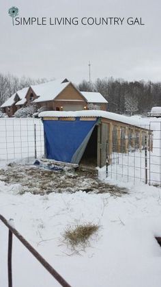 an outhouse in the snow with a blue tarp covering it's door