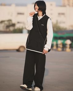 a woman standing in an empty parking lot with her hand on her hip and looking at the camera