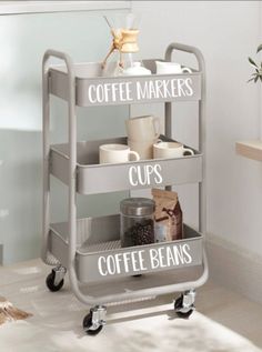 a coffee cart with three shelves holding cups, coffee beans and other items on wheels