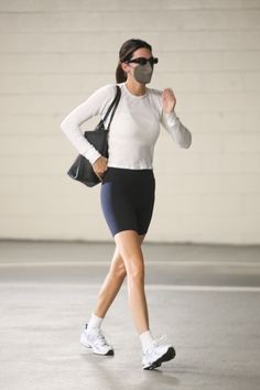 a woman wearing a face mask while running