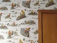 a wallpaper with motorcyclists on it in a room next to a door