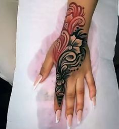 a woman's hand with black and red designs on it