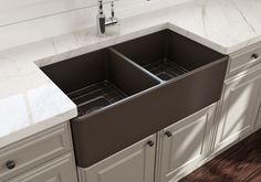 a double black kitchen sink sitting under a faucet next to a white counter top