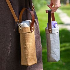 a person holding a cell phone in a bag on the back of their arm,