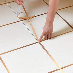 a person measuring the width of a tile floor