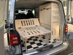 the back end of a van with an open hatchback door and table in it