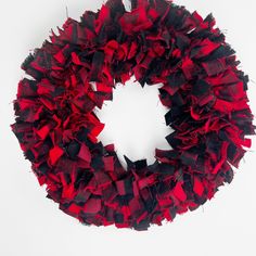 a red and black ruffled wreath on a white background