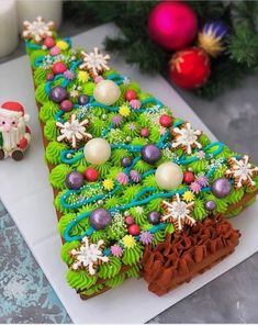 a decorated christmas tree shaped cake next to a candle