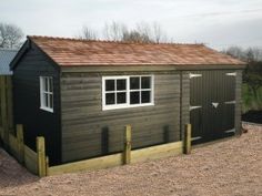 a small wooden shed with a red roof and brown shingles on the side of it