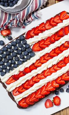 an american flag cake with strawberries and blueberries on top is ready to be eaten