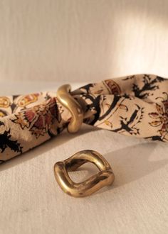 a close up of a gold ring on a white cloth with an animal print background