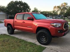 a red truck parked on top of a sidewalk