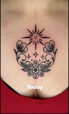 the back of a woman's chest with flowers and stars tattoo on her left side