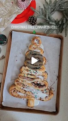 a christmas tree made out of pretzels on top of a baking sheet with the words christmas tree cinnamon roll