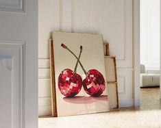 two cherries are displayed in front of an open door with white walls and flooring