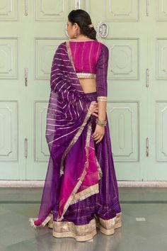 Purple chanderi blend lehenga with gota, sequin work details and border. Paired with magenta embroidered side tie-up blouse and ombre gota work stripes dupatta with fringe lace border. Component: 3 Pattern: Embroidered Type Of Work: Gota and Sequin Work Neckline: Surplice Neck Sleeve Type: Three Quarter Fabric: Chanderi Blend Color: Purple Other Details:  Overlap panel on blouse Tassel details on blouse Occasion: Sangeet,Haldi and Mehendi - Aza Fashions Purple Chanderi Lehenga With Gota Work, Purple Dola Silk Lehenga With Gota Work, Semi-stitched Purple Choli With Gota Work, Purple Lehenga With Gota Work In Dola Silk, Designer Purple Choli With Gota Work, Purple Lehenga With Gota Work For Eid, Fitted Purple Lehenga With Gota Work, Festive Purple Choli With Gota Work, Transitional Purple Chanderi Lehenga