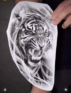 a person holding up a piece of paper with a drawing of a tiger on it