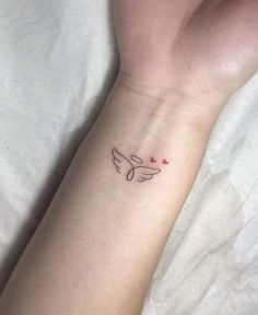 a woman's wrist with a small tattoo on the left side of her arm