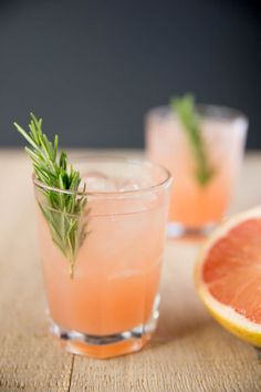 two glasses filled with grapefruit and rosemary garnish