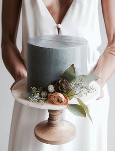 a woman holding a cake with flowers on it