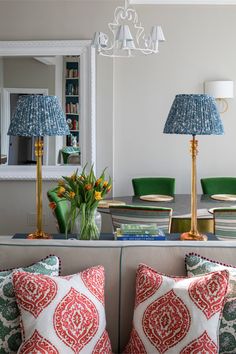 a living room with two couches and lamps on the wall next to each other