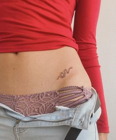 a woman's stomach with a tattoo on her lower belly and the word love written in cursive writing