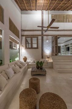 a living room with couches, tables and ceiling fan in the middle of it