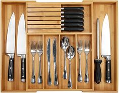 an assortment of knives and spoons in a wooden box with utensils inside