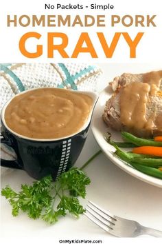 a white plate topped with meat covered in gravy next to green beans and carrots