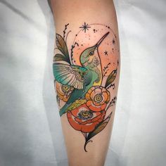 a hummingbird with flowers and stars on it's arm