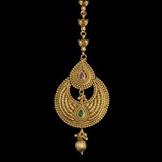 an ornate gold necklace with green stones