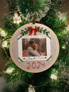 a christmas ornament hanging from the top of a tree with a photo on it