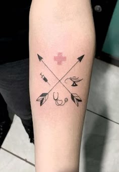 a person with a cross and arrows tattoo on their arm