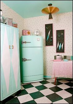 an old fashioned refrigerator in the corner of a room with checkered flooring and wallpaper