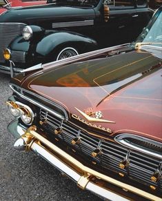 an old fashioned car parked in a parking lot next to other classic cars on display