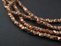 three strands of brown glass beads on a black surface