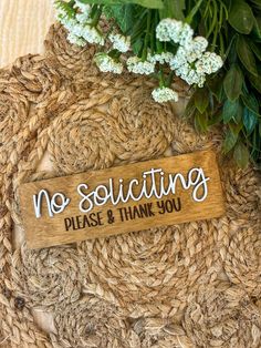 a wooden sign that says no solicing please and thank you on it next to some flowers