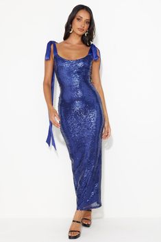 a woman wearing a blue sequin dress with one shoulder and tie at the waist